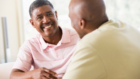 Two men in living room talking about if ADHD is real.