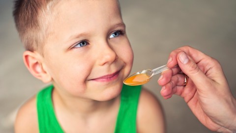 A child taking liquid ADHD medication, which has different side effects than traditional formulations